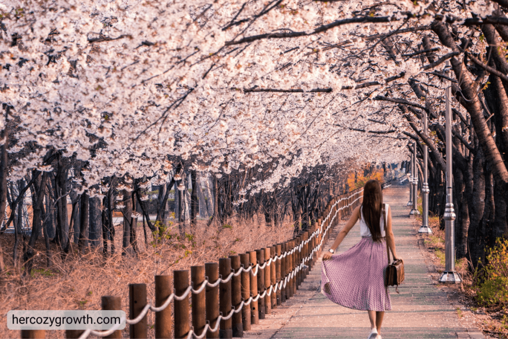 woman walking in spring park with blooming flowers romanticize spring